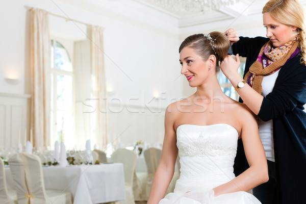 Stylist pinning up a bride's hairstyle Stock photo © Kzenon