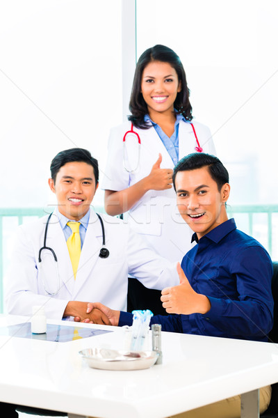 Asian Doctors with Patient in medical office or clinic Stock photo © Kzenon