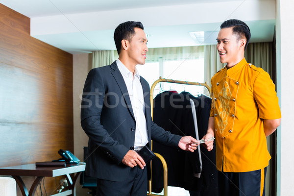 Guest giving tip to a bell boy in hotel room Stock photo © Kzenon
