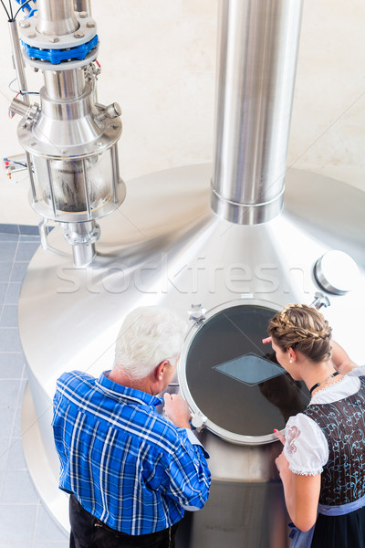 Brewer and couple in beer brewery guided tour Stock photo © Kzenon
