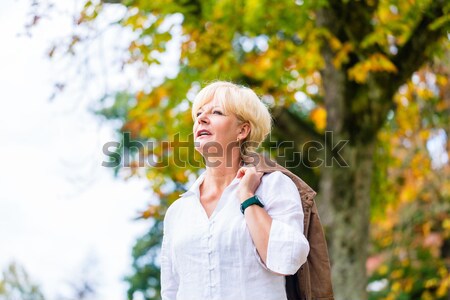 Senior Frau hat Spaß bei Herbst Spaziergang Stock photo © Kzenon