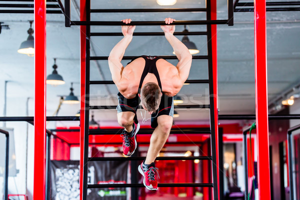 Man at freestyle Calisthenics training in gym Stock photo © Kzenon
