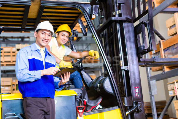 Asian lift truck driver and foreman in storage Stock photo © Kzenon