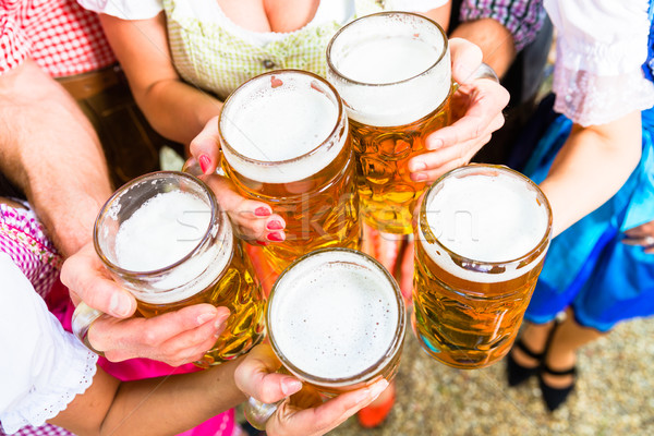 Clinking glasses with beer in Bavarian beer garden Stock photo © Kzenon