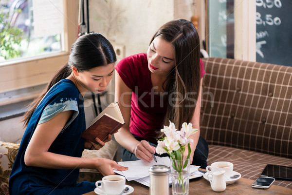 Due giovani business donne coffee shop scritto Foto d'archivio © Kzenon