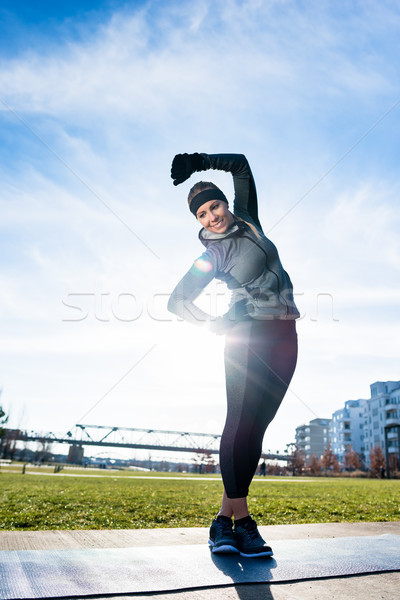 Young woman practicing stretching exercise while standing with c Stock photo © Kzenon