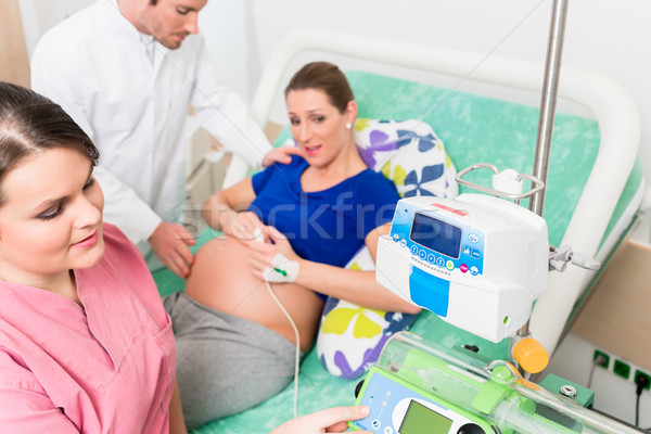 Pregnant woman in labor room with doctor and nurse Stock photo © Kzenon