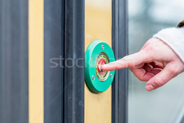 Woman pressing door opener in train Stock photo © Kzenon