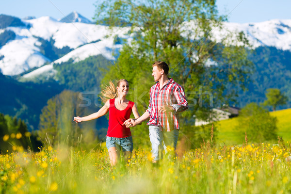 Couple running in the meadow with mountain Stock photo © Kzenon