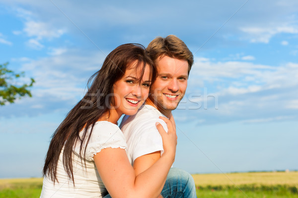 Happy couple on a meadow Stock photo © Kzenon
