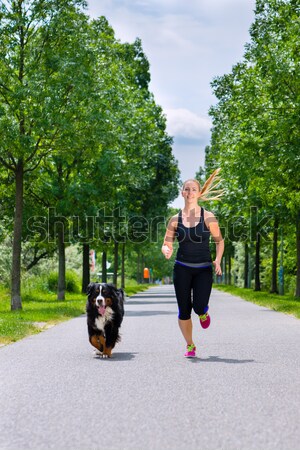 Stock photo: Sports outdoor - young woman running with dog in park