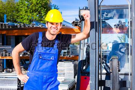 Builder with site pallet transporter or lift fork truck Stock photo © Kzenon
