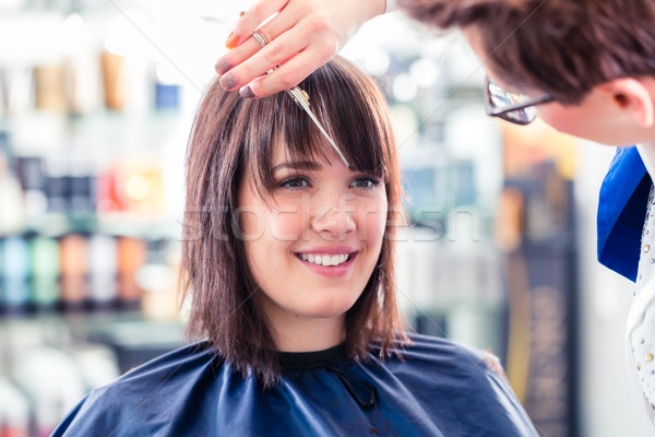 Hairdresser cutting woman hair in shop Stock photo © Kzenon