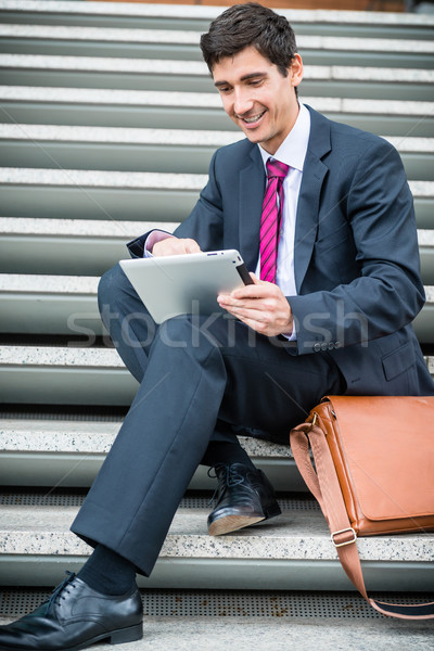 Businessman using a tablet for communication or data storage out Stock photo © Kzenon