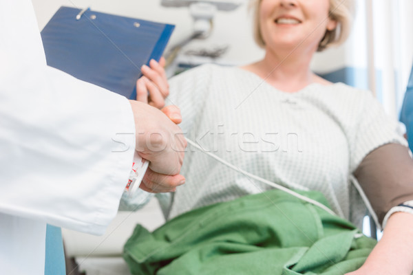 Doctor shaking hands of patient recovering after operation Stock photo © Kzenon