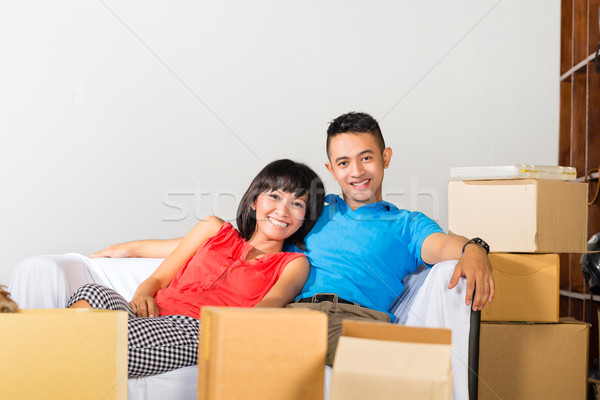 Asian couple having break while moving in Stock photo © Kzenon