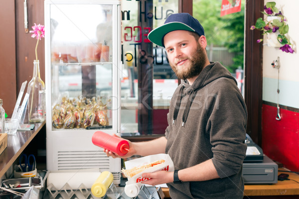 salesman making hotdog in fast food snack bar Stock photo © Kzenon