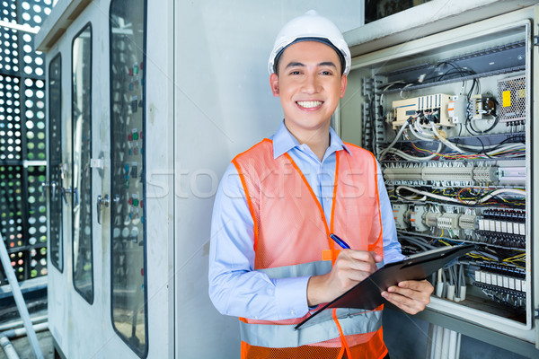 Asian Electrician at panel on construction site Stock photo © Kzenon