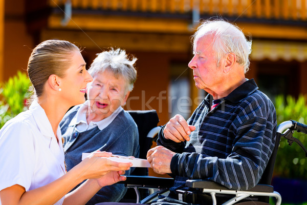 Seniors eating candy in garden of nursing home Stock photo © Kzenon