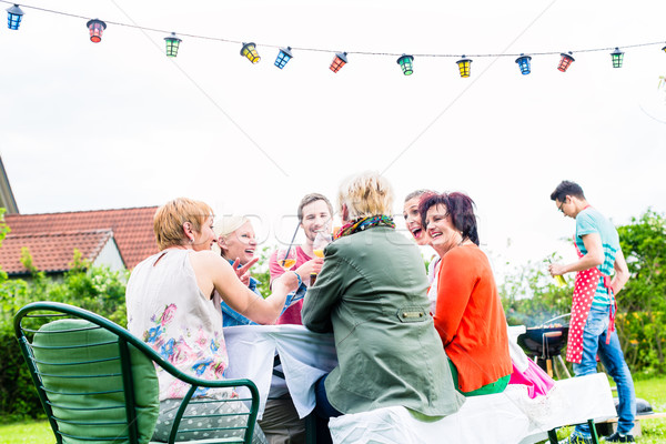 Barátok szomszédok hosszú asztal ünnepel buli Stock fotó © Kzenon