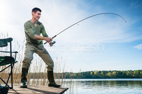 Fisherman catching fish angling at the lake Stock photo © Kzenon