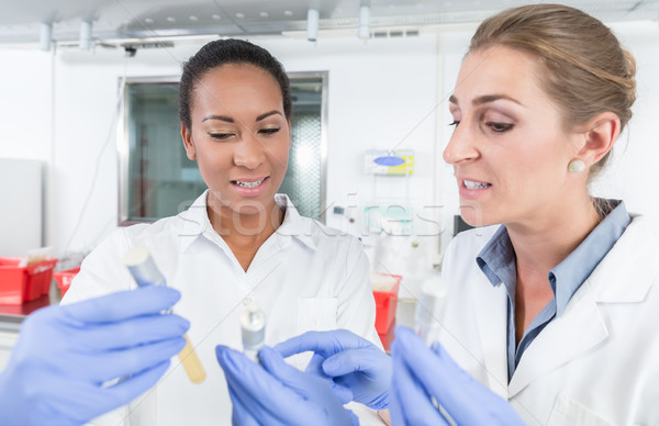 Scientists in research lab with analyzing instrument talking abo Stock photo © Kzenon