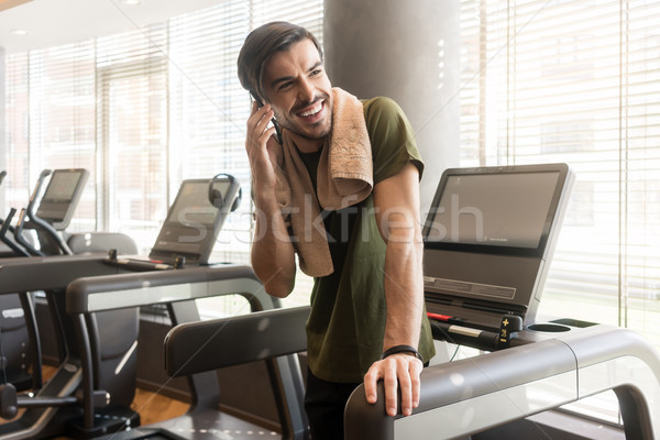 Handsome young man smiling while talking on mobile phone during  Stock photo © Kzenon