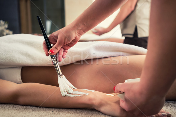 Asian therapist applying rejuvenating moisture balm at beauty ce Stock photo © Kzenon