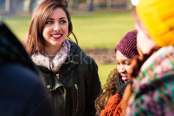 Self-confident young woman surrounded by friends outdoors Stock photo © Kzenon