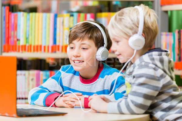 Children in a library listening to audio books Stock photo © Kzenon