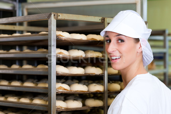 Female baker baking bread rolls Stock photo © Kzenon