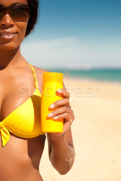 Woman offering suncream on beach Stock photo © Kzenon