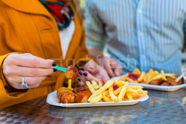 Couple eating German Currywurst at stand Stock photo © Kzenon