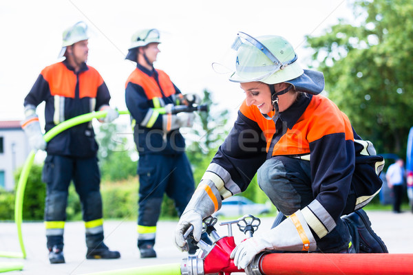 Stock photo: Fire fighter connecting hoses 