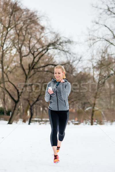 Woman running down a path on winter day in park Stock photo © Kzenon