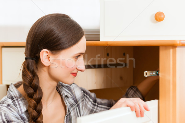 Young woman is assembling a cupboard Stock photo © Kzenon