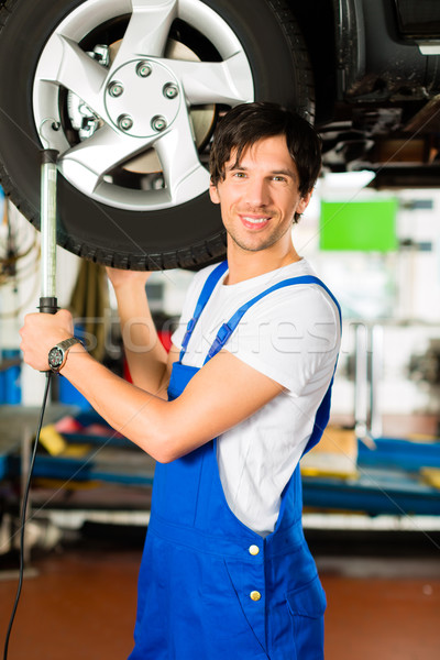 Young mechanic in blue overall working on car Stock photo © Kzenon