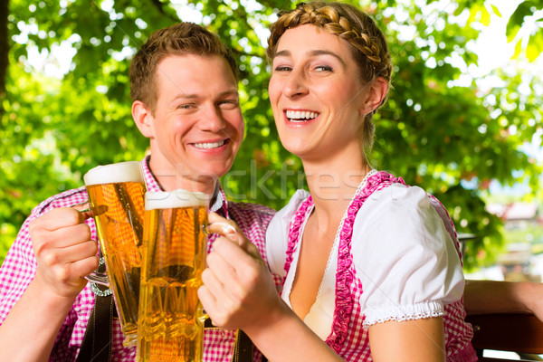 Happy Couple in Beer garden drinking beer Stock photo © Kzenon