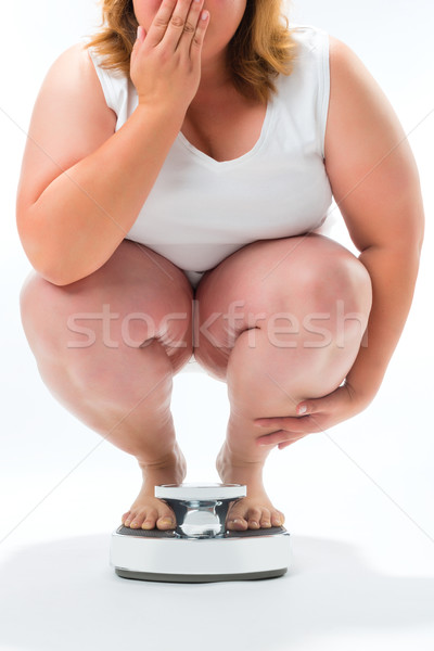 Obese young woman crouching on a scale Stock photo © Kzenon