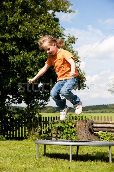 Menina criança trampolim jardim little girl cerca Foto stock © Kzenon