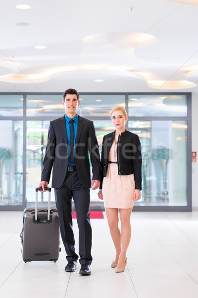 Férfi nő érkezik hotel lobbi bőrönd Stock fotó © Kzenon