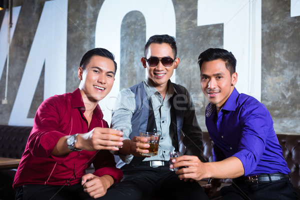 Asian friends drinking shots in nightclub Stock photo © Kzenon