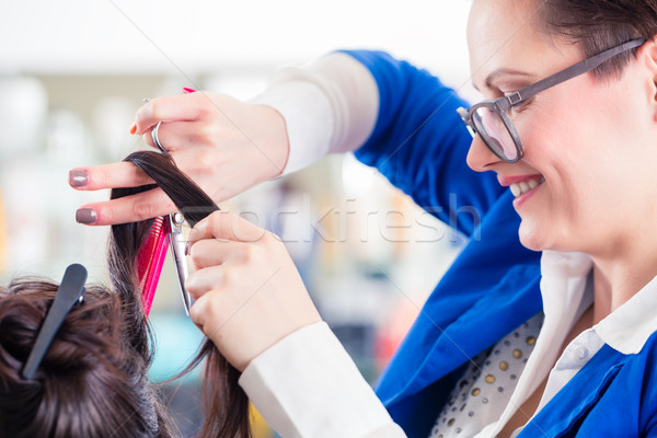 Hairdresser styling woman hair in shop Stock photo © Kzenon