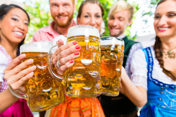 Friends in beer garden with beer glasses Stock photo © Kzenon