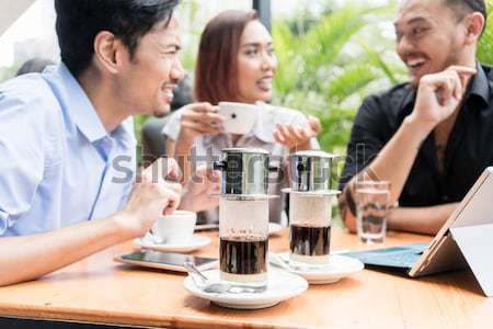 Vietnamese coffee served on the table of three friends outdoors  Stock photo © Kzenon