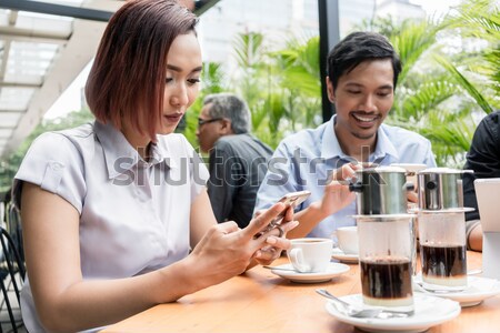 Three friends using devices connected to the wireless internet n Stock photo © Kzenon