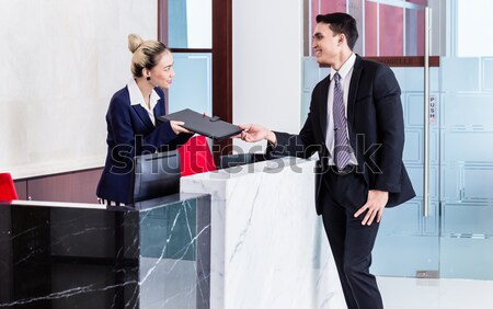 Manager and affiliate leaning at front desk of office  Stock photo © Kzenon