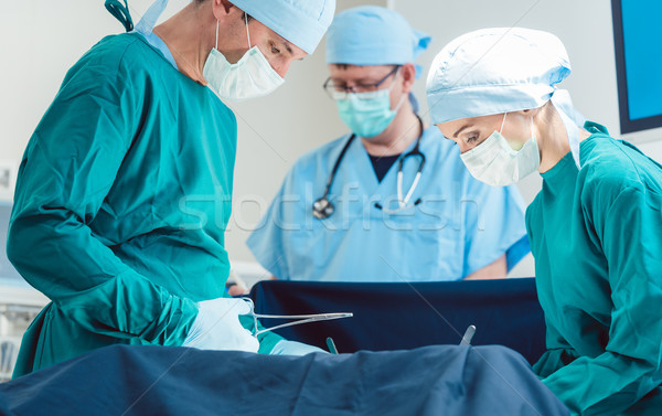 Surgical doctor in full concentration on operation Stock photo © Kzenon