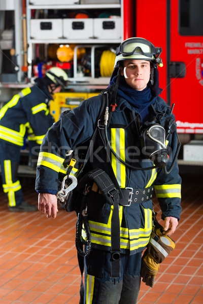 young fireman in uniform in front of firetruck Stock photo © Kzenon