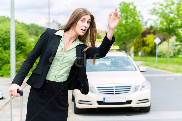 Stock photo: Young businesswoman calls for a taxi